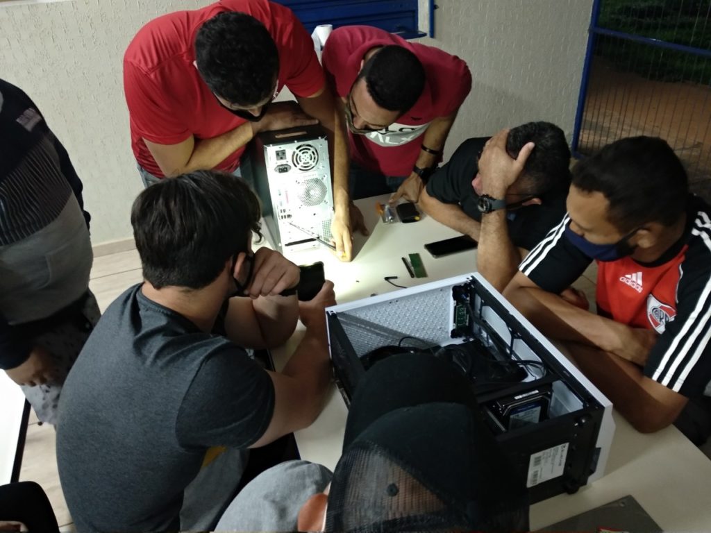 Alunos durante a aula montando um computador.