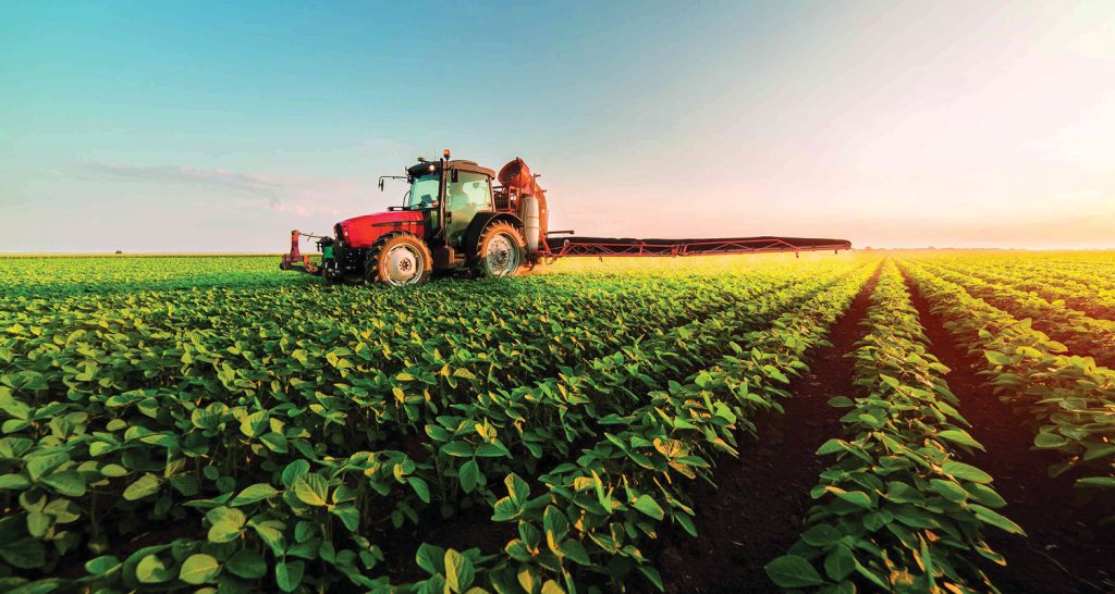 Imagem ilustrativa que exibe um trator sobre um plantação.