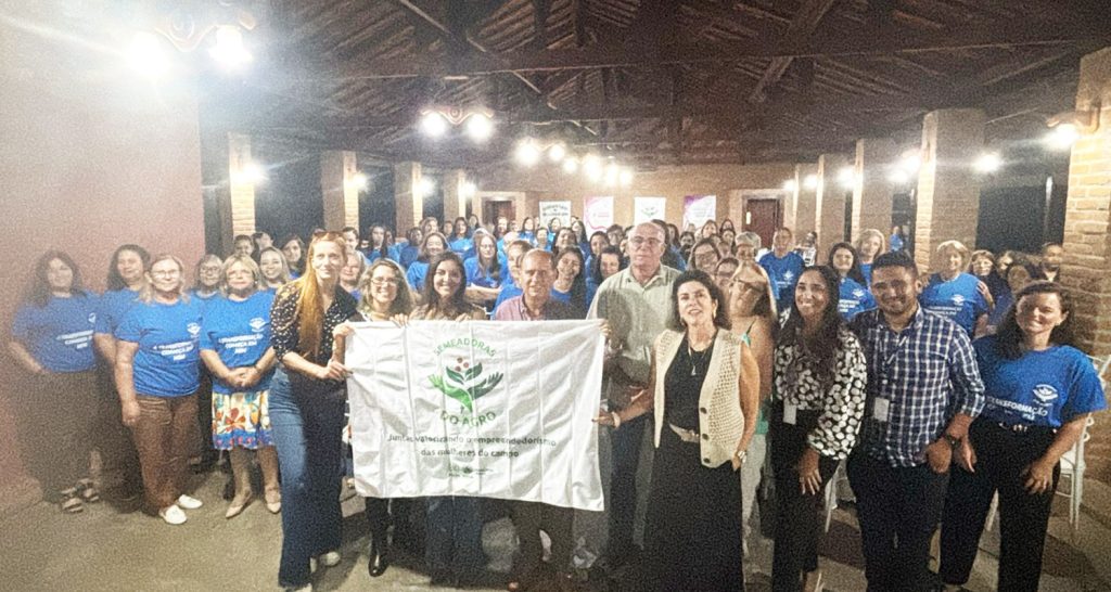 Imagem ilustrativa com o grupo de pessoas no evento da Comissão Semeadoras do Agro no Sindicato Rural de São Sebastião da Grama, vestindo camisetas azuis. 
