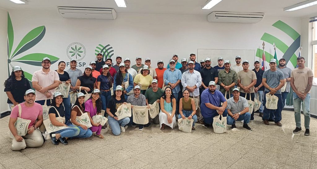 Foto exibe um grupo de pessoas posando para foto e no fundo os logos do sistema Faesp/Senar-SP.