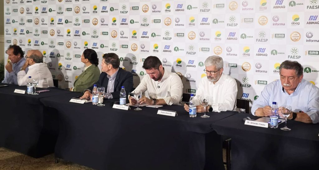 Coletiva referente a feira agrishow 2026 onde várias pessoas estão centadas em uma mesa. 